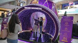 Pengunjung berswafoto di dekorasi perayaan Natal bertema "A Shining Shimmering Christmas" di Mal Grand Indonesia, Jakarta, Senin (13/12/2021). Pengunjung dapat menikmati kemegahan dan kehangatan Natal melalui dekorasi “infinity dome” yang berkilauan indah dan elegan. (Liputan6.com/Faizal Fanani)