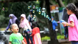 Anak-anak bermain gelembung saat berkunjung ke Ragunan, Jakarta, Minggu (25/12). Ragunan masih menjadi tempat favorit warga untuk mengisi libur panjang. (Liputan6.com/Helmi Afandi)