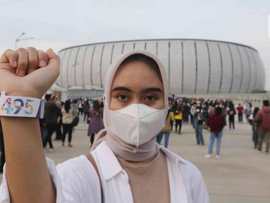 Sorang perempuan menunjukkan gelang akses masuk acara hari ulang tahun (HUT) ke-495 DKI Jakarta atau Jakarta Hajatan di Jakarta International Stadium (JIS), Jakarta Utara, Sabtu (25/6/2022) malam. Pada perayaan Jakarta Hajatan ke-495 di JIS ini dihelat konser yang dimeriahkan oleh musisi kenamaan Tanah Air. (Liputan6.com/Herman Zakharia)