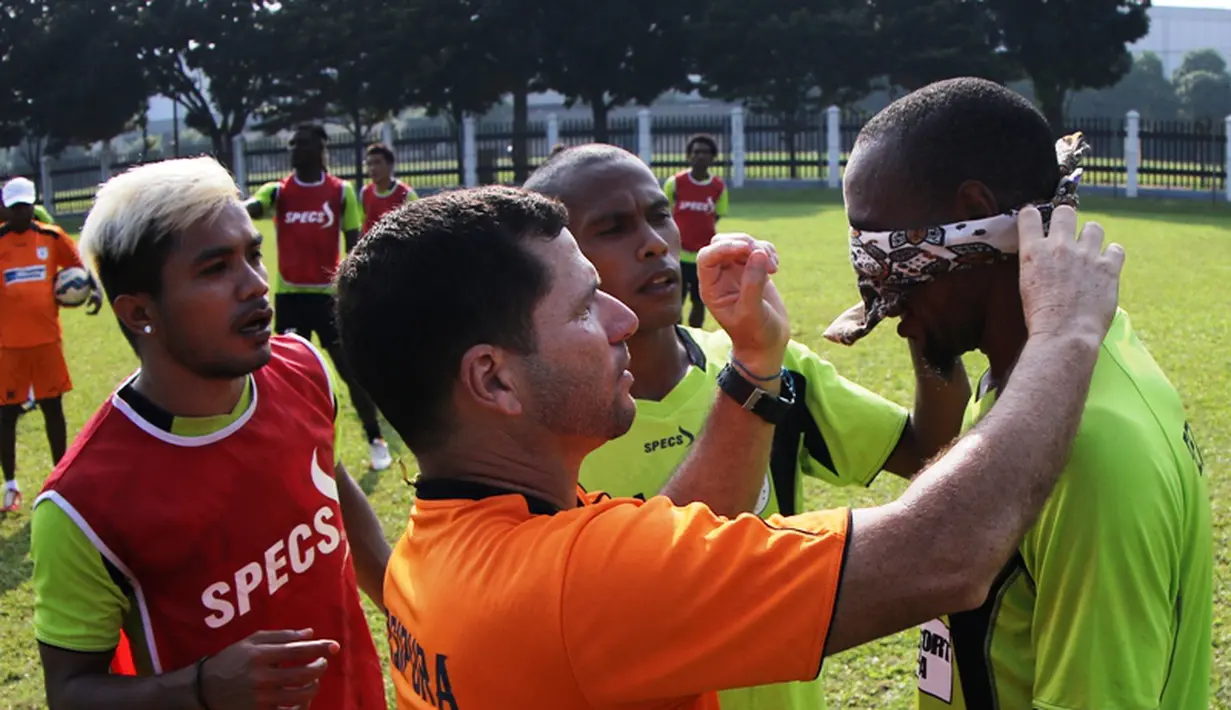 Pelatih Persipura, Osvaldo Lessa, memasang penutup ke mata Lancine Kone saat bermain game mencetak gol ke gawang sambil mata ditutup. (bola.com/Arief Bagus)