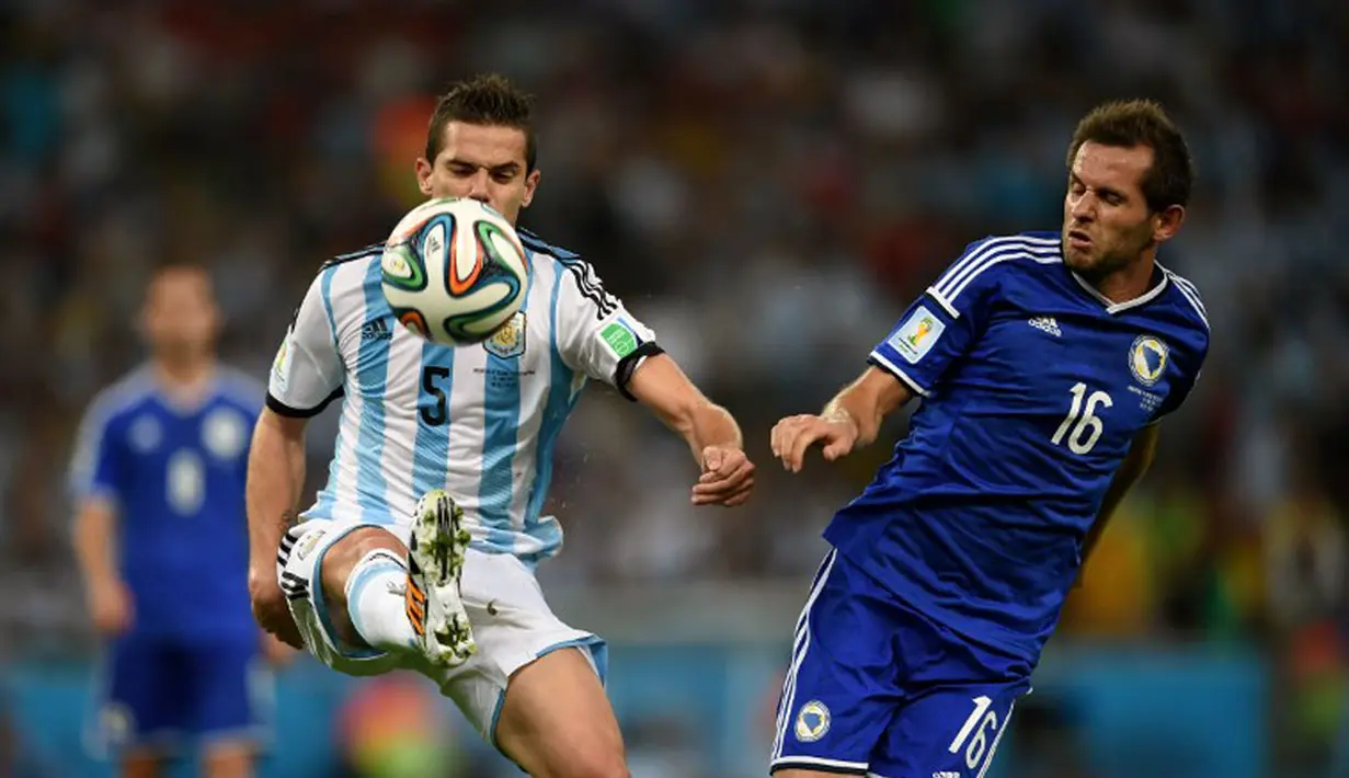 Gelandang Argentina, Fernando Gago (kanan) berduel dengan Senad Lulic (Bosnia-Herzegovina) saat berlaga di penyisihan Piala Dunia 2014 Grup F di Estadio do Maracana, Rio de Janeiro, Brasil, (16/6/2014). (AFP PHOTO/Christophe Simon)