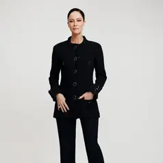 Anna Mouglalis tampil dengan aura refined sophistication lewat setelan hitam klasik khas Chanel. Ia mengenakan tailored jacket berstruktur dengan detail trimming tekstur di bagian tepian, dipadukan celana panjang berpotongan lurus yang memberikan kesan sleek dan powerful. [Dok/Chanel].