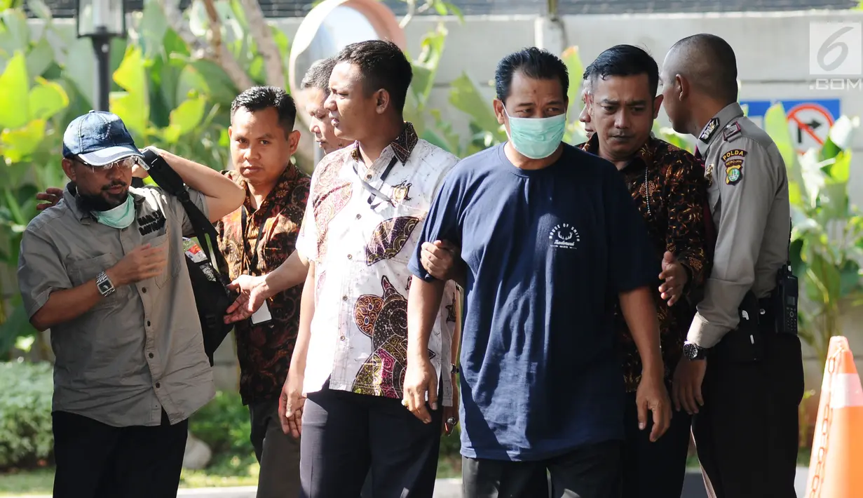 SM Keuangan PDAM Bandarmasih, Transis (kiri) bersama Ketua Pansus penyertaan modal PDAM, Andi Effendi (tutup muka) saat tiba di Gedung KPK, Jakarta, Jumat (15/9). KPK memeriksa empat orang terkait OTT Banjarmasin. (Liputan6.com/Helmi Fithriansyah)