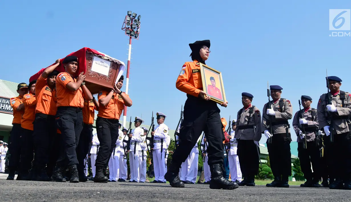 Anggota Basarnas membawa peti jenazah korban jatuhnya helikopter milik basarnas di Lanumad Ahmad Yani, Semarang (3/7). Sebanyak delapan jenazah korban jatunya helikopter Basarnas diserahkan ke pihak keluarga dalam upacara pelepasan. (Liputan6.com/Gholib)