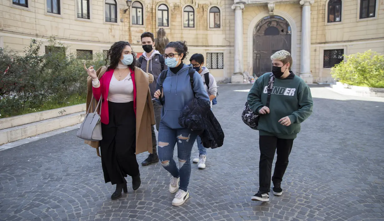 Matteo Coccimiglio (kanan) meninggalkan sekolah seni Ripetta di Roma, 24 Maret 2021. Siswa 18 tahun tersebut mengidentifikasi dirinya sebagai laki-laki, dan sedang dalam proses mengubah status gendernya dari perempuan menjadi pria. (AP Photo/Alessandra Tarantino)
