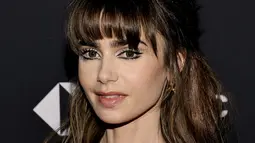 Lily Collins berpose saat menghadiri Time100 Next di New York City, Amerika Serikat, 25 Oktober 2022. Bintang Emily In Paris itu menata rambut cokelatnya yang cantik menjadi sanggul, sementara sebagian besar jatuh ke tengkuknya. (Jamie McCarthy/Getty Images/AFP)