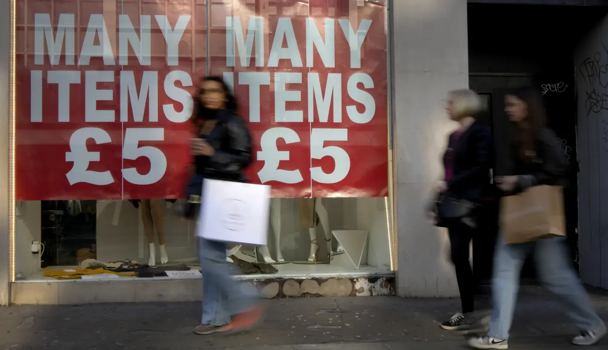 Pembeli melewati tanda di etalase toko di Oxford Street di London, Rabu (15/2/2023). Tingkat inflasi tahunan di Inggris turun menjadi 10,1% pada Januari 2023 dari 10,5% pada Desember, di bawah perkiraan pasar 10,3%. (AP Photo/Kirsty Wigglesworth)