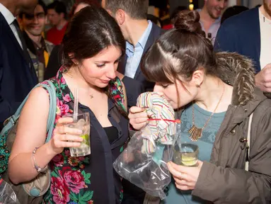Seorang wanita tengah mencium aroma kaos lawan jenis dalam Pheromone Party di London, Inggris. (AFP PHOTO/Stories Bar)