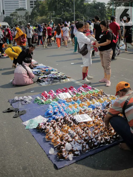 Pedagang kaki lima (PKL) berjualan di jalan saat car free day (CFD) di kawasan Bundaran HI, Jakarta, Minggu (6/10/2019). Banyaknya PKL nakal yang berjualan tidak pada tempatnya menyebabkan olahraga warga terganggu. (Liputan6.com/Faizal Fanani)
