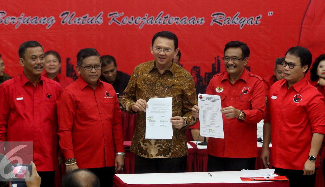 Basuki Tjahaja Purnama (tengah) dan Djarot Saiful Hidayat (kedua kanan) menunjukkan kontrak politik dengan PDIP, Jakarta, Selasa (20/9).  PDIP resmi mengusung Ahok dan Djarot pada Pilgub DKI 2017. (Liputan6.com/Herman Zakharia)