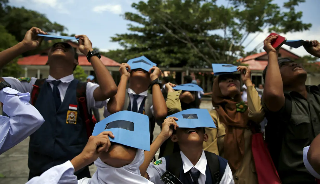Siswa dan Guru menjajal kacamata filter saat workshop bersama Hong Kong Astronomical Society dan LAPAN di sekolah di Ternate, (7/3). Gerhana Matahari Total akan melintasi sejumlah kota di Indonesia pada 9 Maret 2016 mendatang. (REUTERS/Beawiharta)