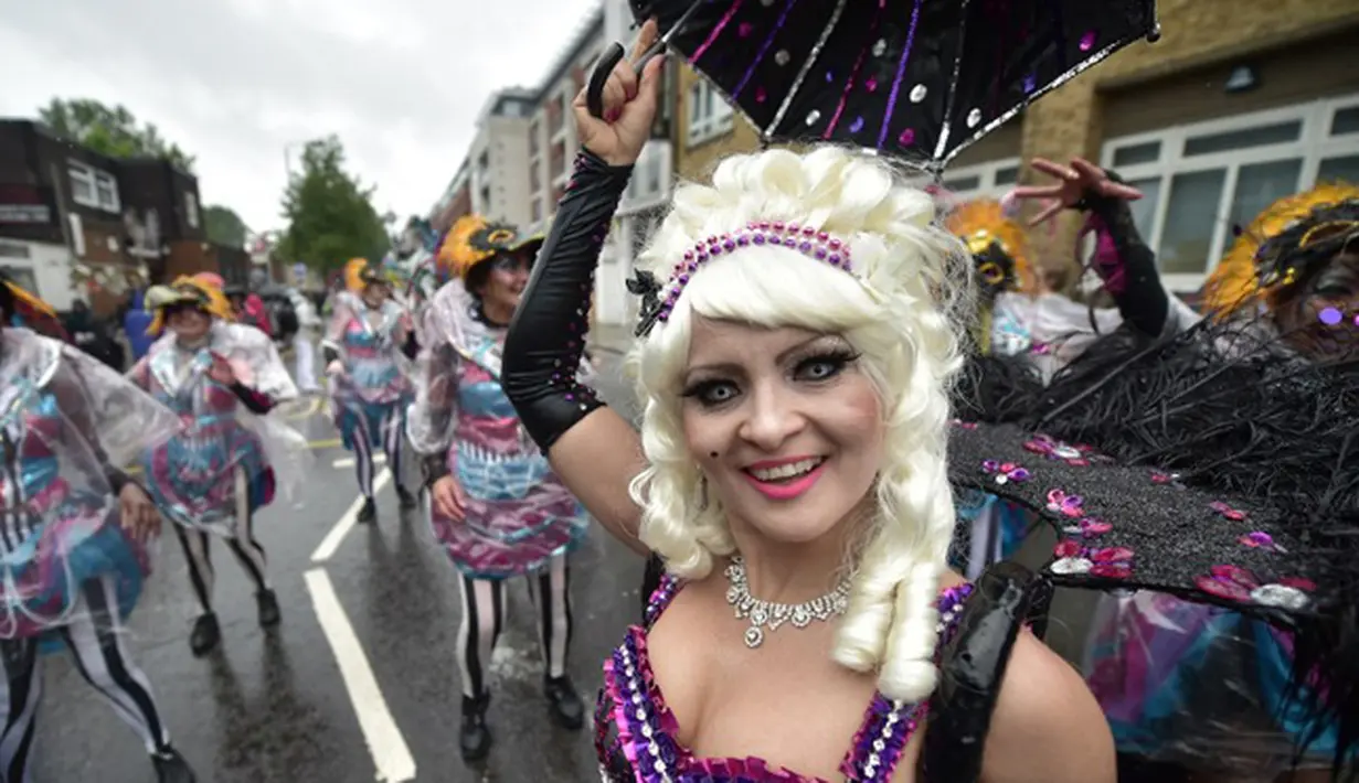 Seorang penari tersenyum saat tampil di Karnaval Notting Hill di London,Inggris (31/8/2015). Karnaval Notting Hill diadakan untuk merayakan budaya Karibia yang sudah dikenal sejak 1960-an. (AFP PHOTO/LEON Neal)