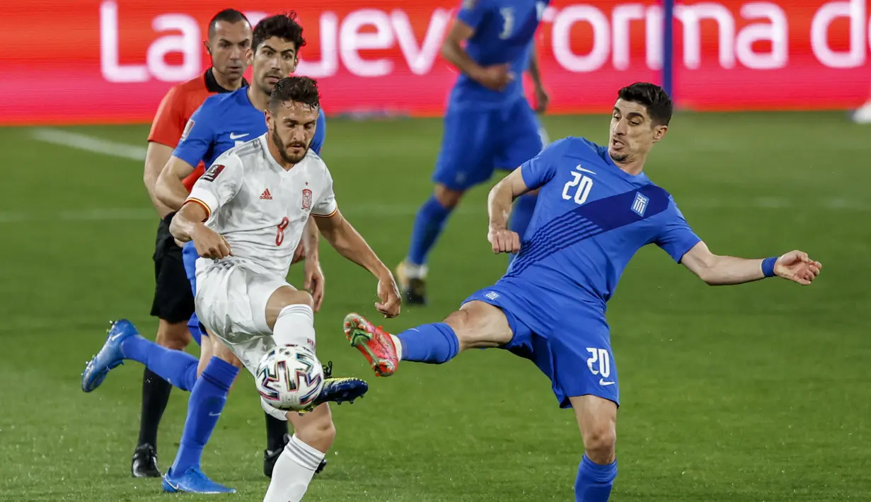 Gelandang Spanyol, Koke (kiri) berebut bola dengan gelandang Yunani, Petros Mantalos dalam laga Kualifikasi Piala Dunia 2022 Zona Eropa Grup B di Los Carmenes Stadium, Granada, Kamis (25/3/2021). Spanyol bermain imbang 1-1 dengan Yunani. (AP/Fermin Rodriguez)
