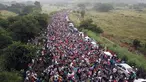 Rombongan imigran Amerika Tengah tujuan Amerika Serikat berkumpul di jalan raya setelah polisi federal memblokir jalan mereka di luar Kota Arriaga, Meksiko, Sabtu (27/10). Pemerintah Meksiko menghalangi rombongan menuju AS. (AP Photo/Rodrigo Abd)
