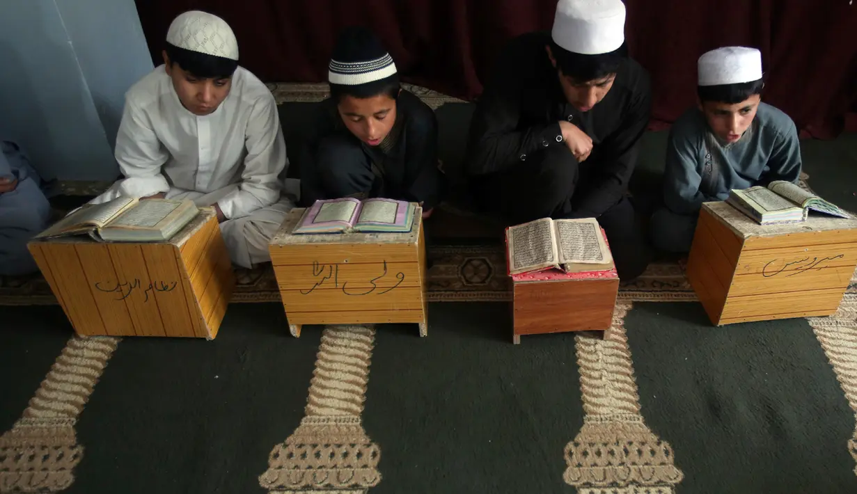 Anak-anak belajar membaca Alquran di sebuah masjid di Kabul, Afghanistan, Senin, (21/5). Anak-anak Afghanistan lebih memperdalam Alquran di saat Ramadan. (AP Photo/Rahmat Gul)