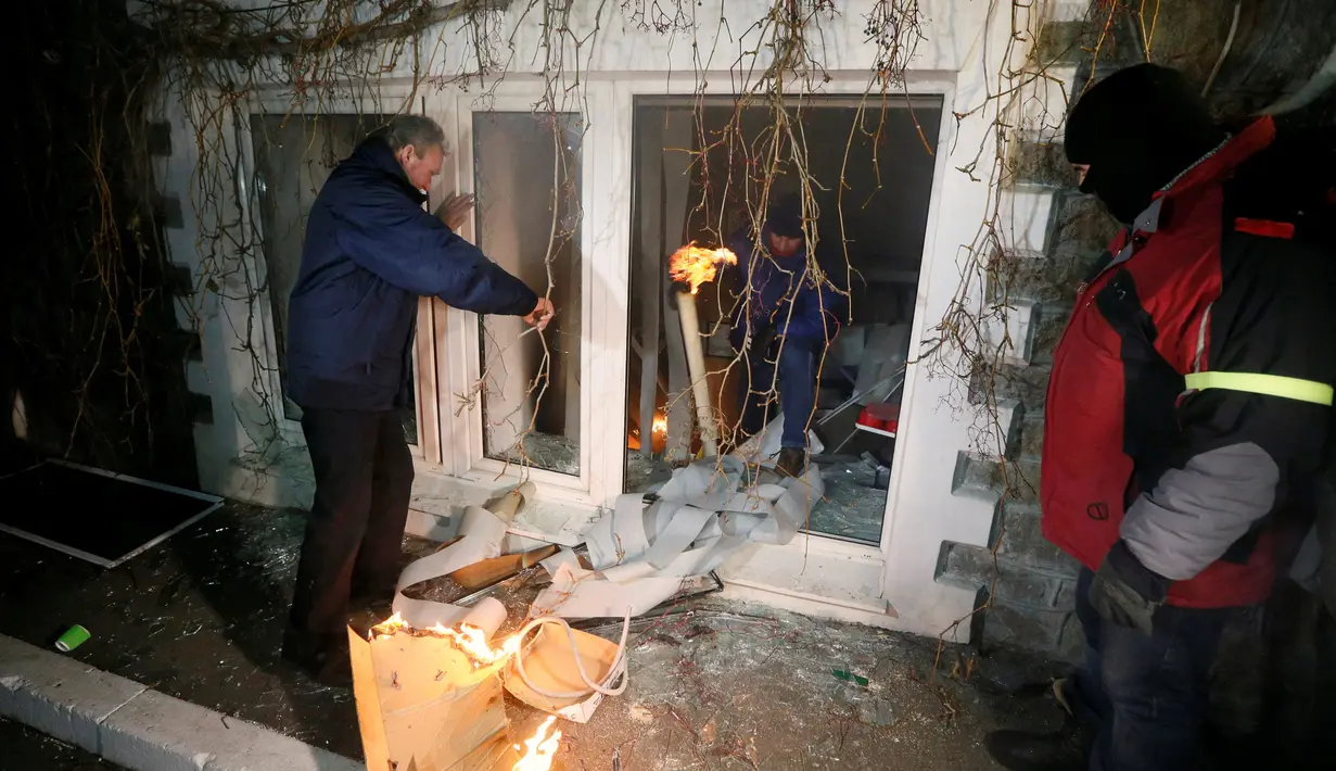 Para demonstran membakar fasilitas bank Rusia, Sberbank di Kyiv, Ukraina, (21/11). Aksi dilakukan untuk memperingati tragedi kerusuhan 2014 yang menyebabkan lebih dari 100 warga Ukraina tewas. (REUTERS/Valentyn Ogirenko)