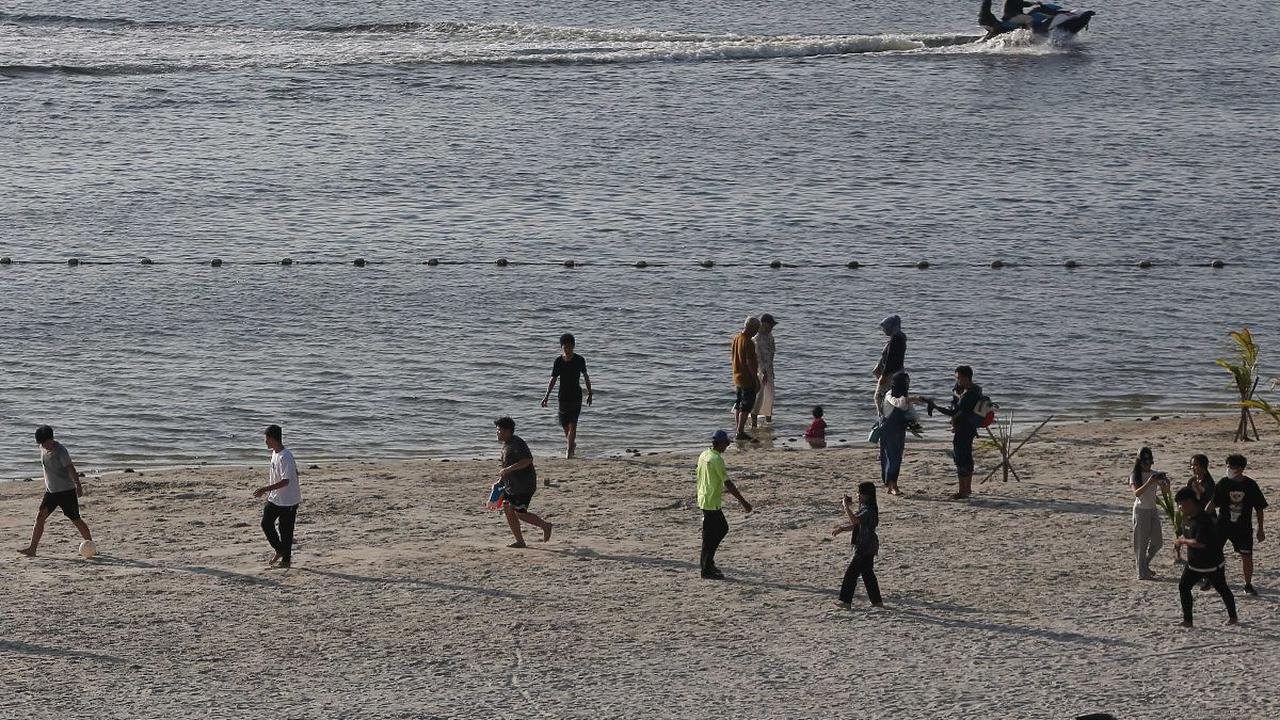 Sejumlah pengunjung menikmati suasana pantai Ancol saat libur panjang perayaan Waisak 2568 BE, Jakarta, Jumat (24/5/2024).&nbsp;Libur panjang perayaan Waisak 2024 dimanfaatkan warga untuk berekreasi ke tempat wisata di Jakarta. Foto: Liputan6.com/Angga Yu