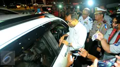 Menteri Perhubungan (Menhub) Budi Karya Sumadi saat berbincang dengan supir mobil pribadi di pintu keluar tol Brebes Timur atau Brexit Jumat (23/12). Menhub mengatakan arus lalu lintas ramai lancar pada mudik Natal 2016. (Liputan6.com/Angga Yuniar)