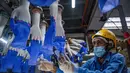 Seorang pekerja memeriksa sarung tangan sekali pakai di pabrik Top Glove di Shah Alam di pinggiran Kuala Lumpur (26/8/2020). Top Glove, sebuah perusahaan yang berbasis di Malaysia adalah salah satu produsen sarung tangan karet terbesar di dunia. (AFP/Mohd Rasfan)
