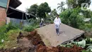 Warga berjalan melintasi jalan yang rusak akibat gempa di Desa Sarampad, Kabupaten Cianjur, Jawa Barat, Selasa (22/11/2022). Warga yang terdampak gempa berharap bantuan seperti makanan, obat-obatan, selimut, dan petugas medis bisa segera datang. (Liputan6.com/Herman Zakharia)