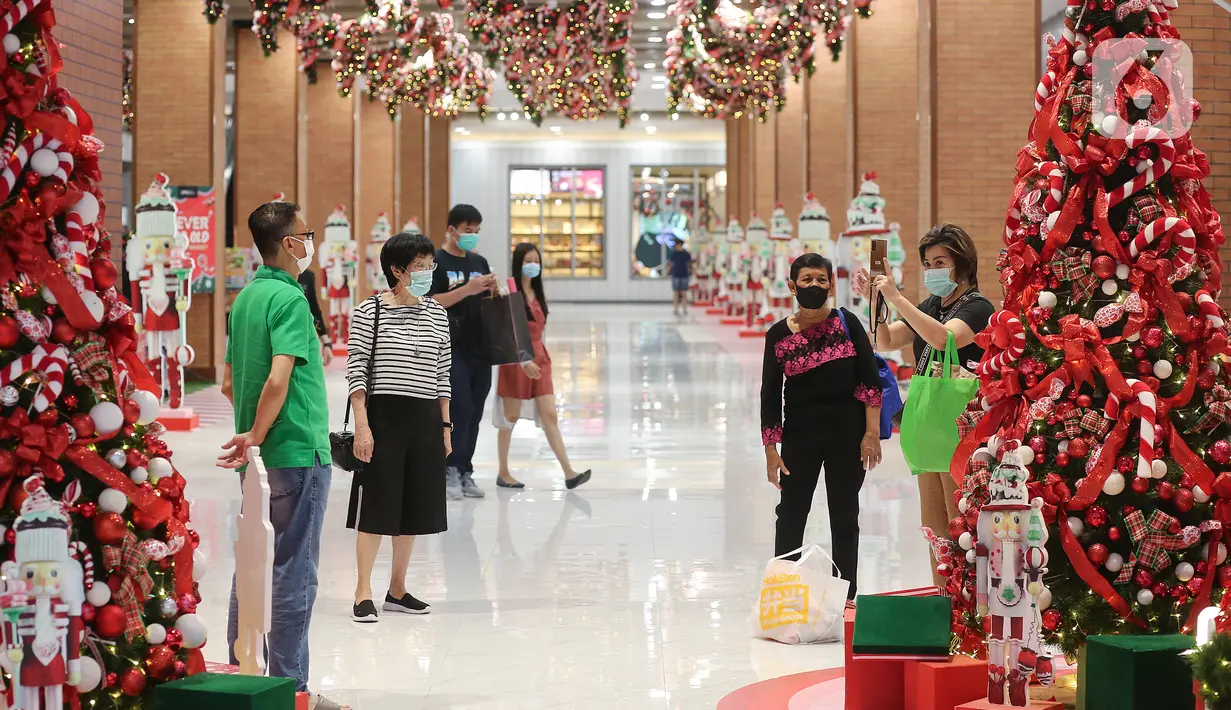 Pengunjung saat foto dengan dekorasi Natal di Grand Central Lippo Mall Puri, Jakarta, Minggu (5/12/2021). Dekorasi bertema  Classic Christmas dengan pohon natal yang dominan berwarna hijau dan merah serta berjajar nutracker menyambut pengunjung. (Liputan6.com/Fery Pradolo)