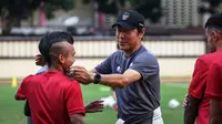 Pelatih Kepala Timnas Indonesia, Shin Tae-yong (kanan kedua) bercanda dengan pemainnya, Riko Simanjuntak (tengah) dan penerjemahnya, Jeong Seok-seo saat latihan perdana Timnas Indonesia yang berlangsung di Stadion PTIK, Jakarta, Senin (20/03/2023) sore WIB. Skuad Garuda rencananya akan melakoni laga FIFA Match Day melawan Burundi pada 25 dan 28 Maret 2023 di Stadion Patriot Candrabhaga, Bekasi. (Bola.com/Bagaskara Lazuardi)