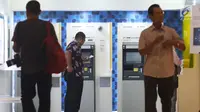 Pengunjung melakukan penarikan uang melalui ATM di kawasan Jakarta, Jumat (25/1). Sepanjang 2018, volume transaksi debit Mandiri tumbuh 6% secara year on year (yoy), sedangkan dari sisi nominalnya tumbuh 7% yoy. (Liputan6.com/Angga Yuniar)