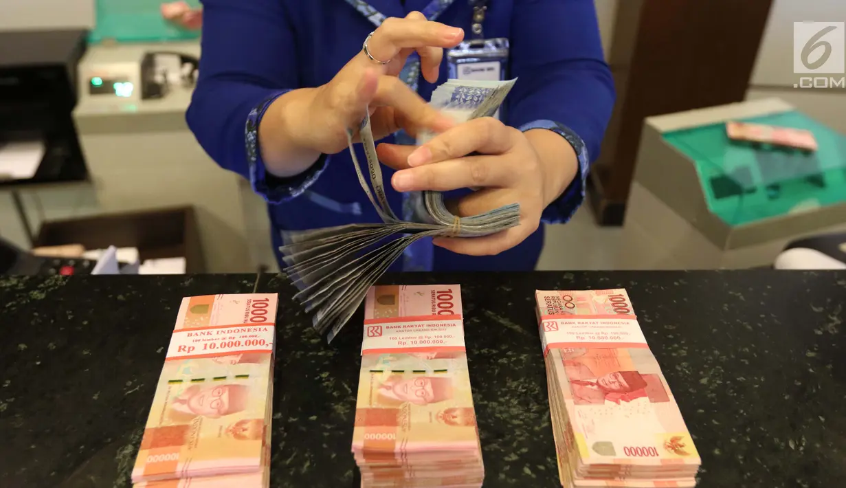 Petugas tengah menghitung uang rupiah di Bank BUMN, Jakarta, Selasa (17/4). Mengacu data Bloomberg, rupiah siang ini pukul 12.00 WIB di pasar spot exchange sebesar Rp 13.775 per dolar AS atau menguat 4,7 poin. (Liputan6.com/Angga Yuniar)