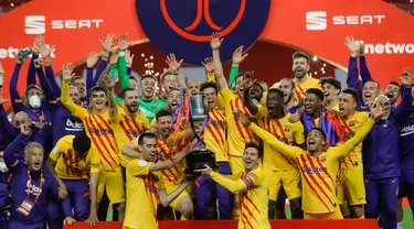 Para pemain Barcelona memegang trofi saat mereka merayakan kemenangan setelah memenangkan final Copa del Rey Spanyol 2021 melawan Athletic Bilbao di stadion La Cartuja di Seville, Spanyol, Minggu (18/4/2021). Barcelona menang atas Athletic Bilbao 4-0.  (HANDOUT / RFEF / AFP)