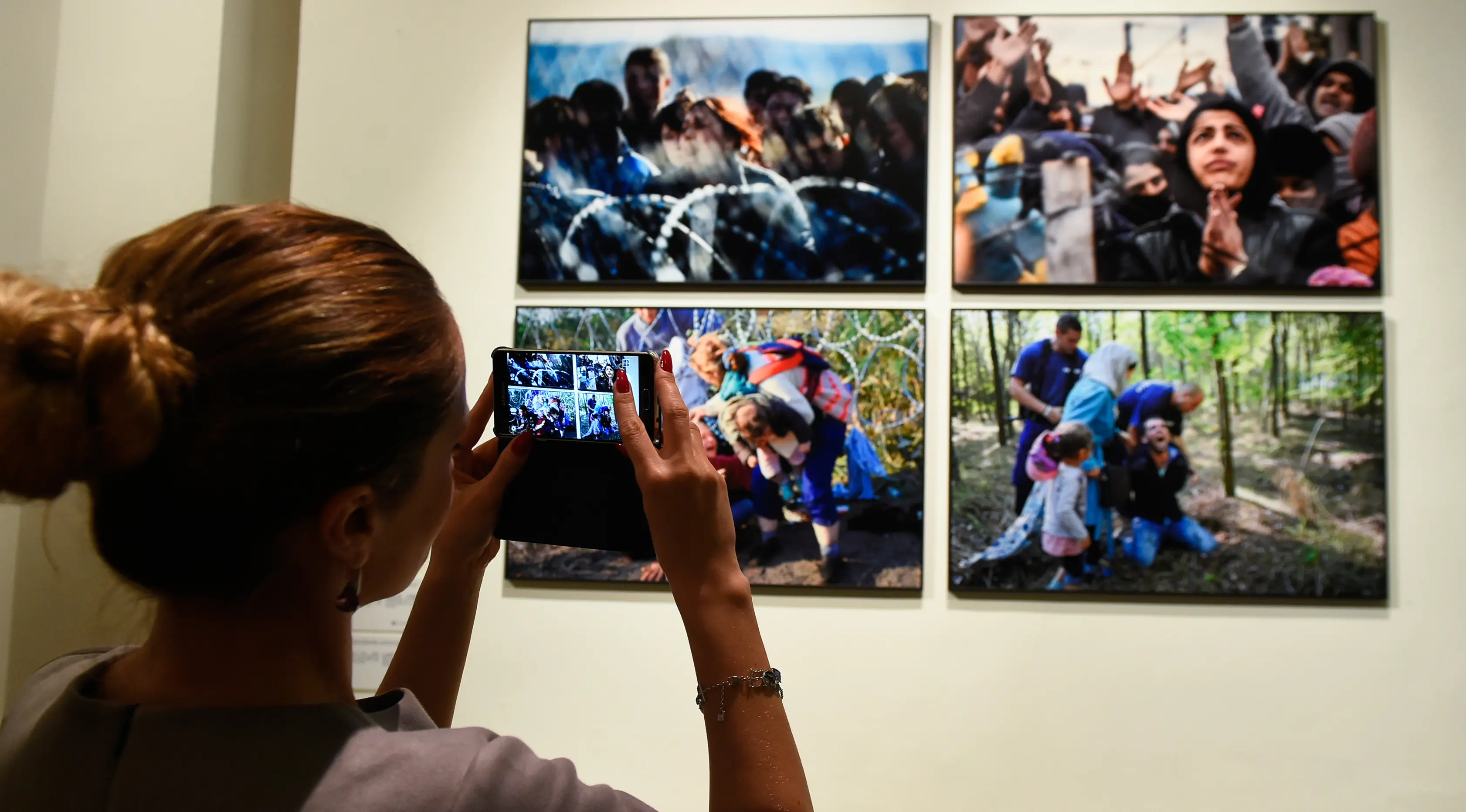 Pengunjung mengambil foto saat pameran karya fotografer Agence France-Presse (AFP) mengenai krisis migrasi di Eropa di pusat seni Bozar di Brussels (3/5). Pameran ini berjudul 