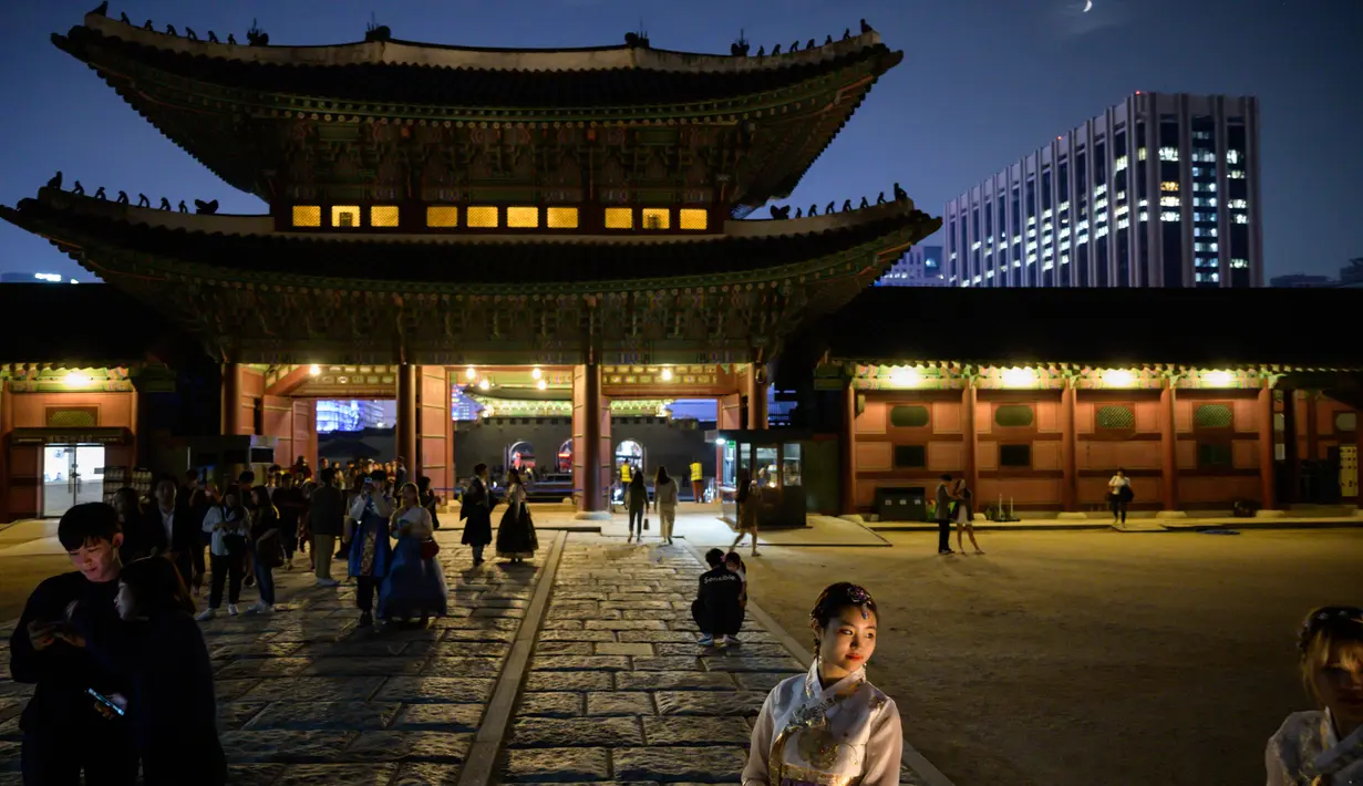 Gambar pada 4 Oktober 2019 memperlihatkan wisatawan saat kunjungan malam ke Istana Gyeongbokgung di pusat Seoul, Korea Selatan. Kunjungan malam tersedia pada minggu ketiga dan keempat setiap bulan mulai dari 26 April sampai 31 Oktober, kecuali pada bulan Agustus. (Photo by Ed JONES / AFP)
