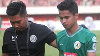 Pemain sayap PSS Sleman, Irkham Zahrul Mila (kanan) ditemani tim medis usai mengalami cedera saat melawan Madura United di Stadion Maguwoharjo, Minggu (29/9/2019). (Bola.com/Vincentius Atmaja)