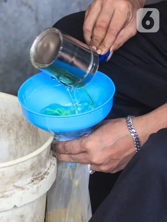 Pedagang memasukkan minyak goreng curah ke dalam kantong plastik di Pasar Kebayoran, Jakarta, Selasa (31/5/2022). Pencabutan menyusul dikeluarkannya Permendag Nomor 30 Tahun 2022 yang mengatur ketentuan ekspor CPO dan turunan lainnya dan Permendag Nomor 33 Tahun 2022 tentang Tata Kelola Minyak Goreng Curah Sistem DMO-DPO. (Liputan6.com/Johan Tallo)
