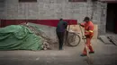 Seorang pekerja menyapu jalan di daerah hutong di Beijing (26/2). Hutong adalah jenis jalan sempit atau gang yang biasanya dikaitkan dengan kota-kota Cina utara, terutama Beijing.  (AFP Photo/Nicolas Asfouri)