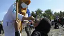 Pekerja medis memberikan imunisasi polio dari petugas medis saat berlangsung vaksinasi massal di Sigli Town Square,  Pidie, Aceh, Senin (28/11/2022).  Menyusul kejadian luar biasa (KLB) polio beberapa pekan lalu di Kabupaten Pidie, pemerintah memberikan imunisasi polio tambahan pada anak usia 0-13 tahun di seluruh wilayah Provinsi Aceh . (AP Photo/Riska Munawarah)