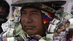 Seseorang berpakaian seperti Ekeko, Dewa Kemakmuran, diselimuti uang palsu pada hari pembukaan Pameran Alasita tahunan, di mana Ekeko adalah tokoh utamanya di El Alto, Bolivia, Selasa (24/1/2023). Orang-orang membeli replika kecil dari hal-hal yang ingin mereka peroleh sepanjang tahun, seperti rumah, mobil, dan kekayaan. Kata Aymara "Alasita" berarti "belikan aku". (AP Photo/Juan Karita)