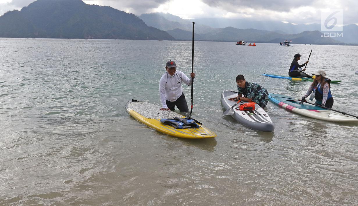 Direktur Utama Ketenagakerjaan, Agus Susanto dan Bupati Trenggalek, Mochammad Nur Arifin usai olah raga  Stand Up Paddle di Pantai Mutiara, Trenggalek, Jawa Timur, Sabtu (7/9/2019). (Liputan6.com/Herman Zakharia)