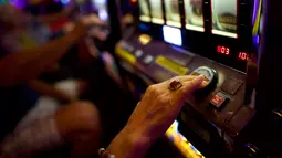 Seorang wanita lansia menekan tombol saat bermain mesin slot di Dover Downs Casino, Delaware (5/6). Legalisasi ini dilakukan sejak keputusan Mahkamah Agung yang mencabut larangan federal setelah 25 tahun lalu. (Mark Makela/Getty Images North America/AFP)