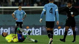 Neymar tampak seperti salah tumpuan saat berebut bola dengan pemain Uruguay. (Pablo PORCIUNCULA / AFP)