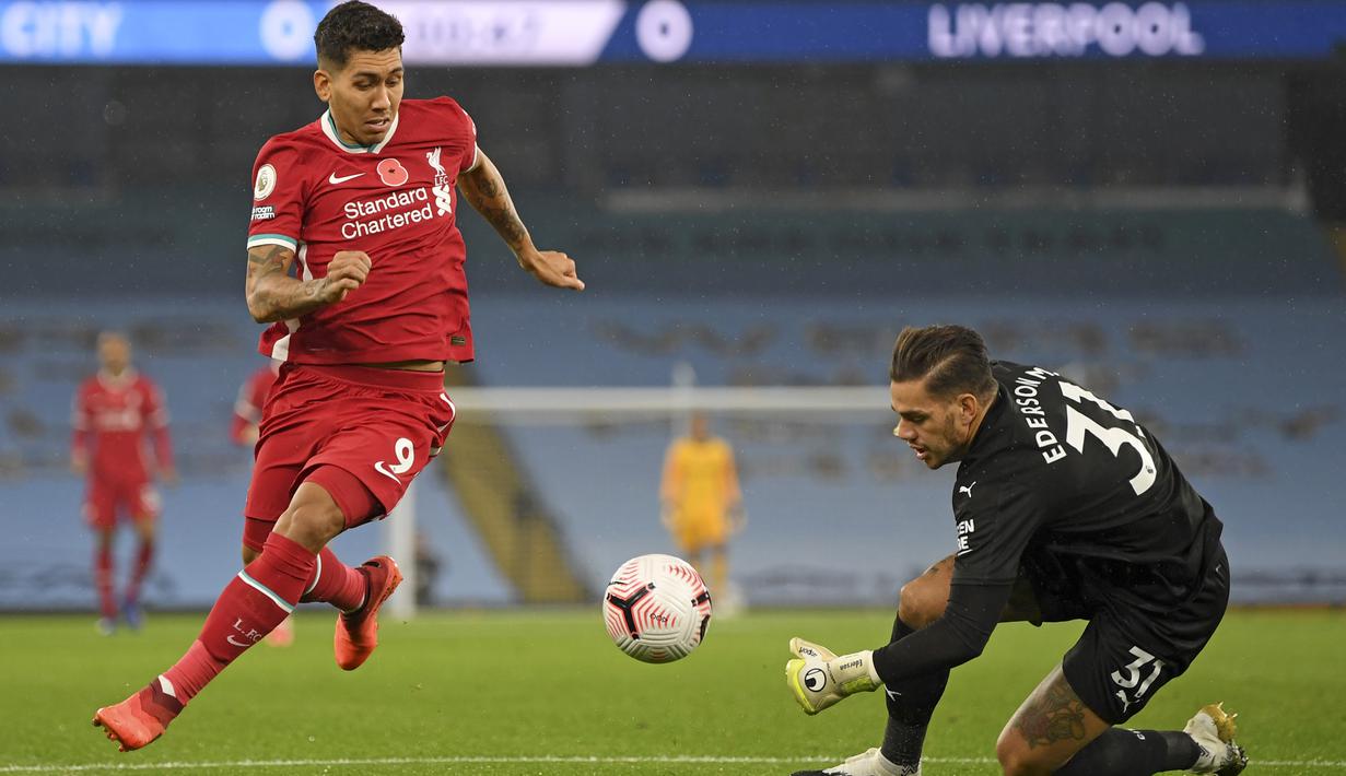 Penyerang Liverpool, Roberto Firmino mencoba untuk melewati kiper Manchester City Ederson pada pertandingan Liga Inggris pekan ke-8 di Etihad Stadium, Minggu (8/11/2020). Manchester City gagal mengalahkan Liverpool dan harus puas berbagi angka setelah bermain imbang 1-1 (Shaun Botterill/Pool via AP)