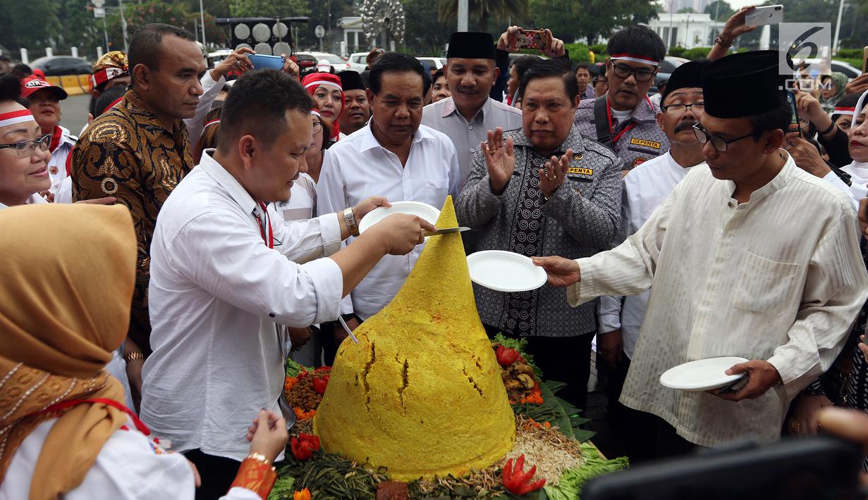 Relawan Indonesia Bersatu menggelar aksi potong tumpeng di depan Istana Negara, Jakarta, Jumat (5/7/2019). Aksi tersebut merupakan syukuran atas terpilihnya Joko Widodo atau Jokowi sebagai Presiden RI untuk kedua kalinya. (Liputan6.com/JohanTallo)