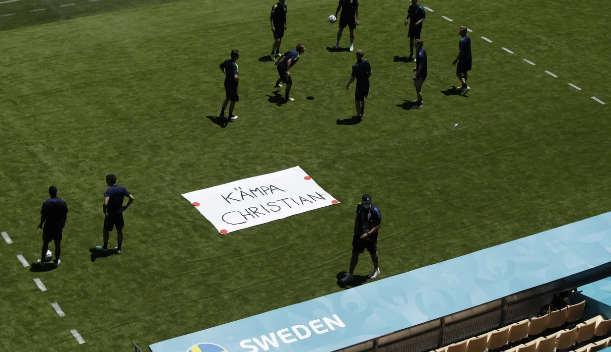 Tim Swedia berpose di sebelah tanda bertuliskan "Get Well Christian" untuk gelandang Denmark Christian Eriksen selama sesi latihan di stadion La Cartuja di Seville, Spanyol, Minggu (13/6/2021). Swedia akan bertanding melawan Spanyol pada Grup E Euro 2020.  (AP Photo/Thanassis Stavrakis)