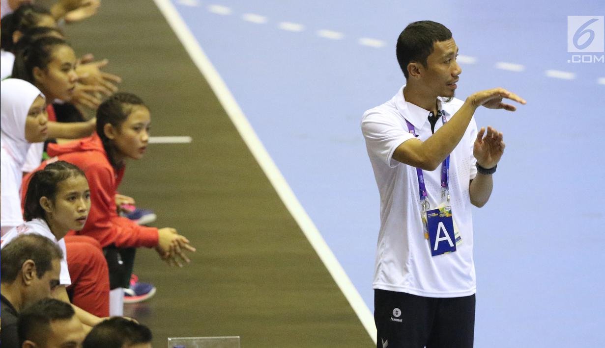 Pelatih timnas bola tangan putri Indonesia, Abdul Kadir memberi arahan pada timnya saat melawan Thailand di babak penyisihan grup B Asian Games 2018 di Jakarta, Kamis (16/8). Indonesia kalah 16-34. (Liputan6.com/Helmi Fithriansyah)