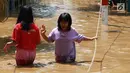 Dua anak melintasi banjir yang menggenangi kawasan Pejaten Timur, Jakarta, Jumat (26/4). Banjir yang berasal dari luapan Sungai Ciliwung tersebut merendam ratusan rumah warga hingga kedalaman lebih dari satu meter. (Liputan6.com/Immanuel Antonius)