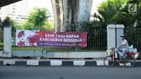 Pedagang melintas di sisi spanduk dukungan untuk Gatot Nurmantyo di kawasan Cikini, Jakarta, Minggu (1/4). Terdapat tulisan "Pemimpin masa depan Indonesia 2019-2024," pada spanduk yang tidak diketahui siapa pemasangnya. (Liputan6.com/Helmi Fithriansyah)