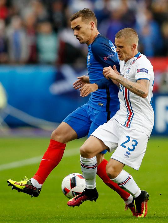 Bek Islandia, Ari Skulason (kanan) berebut bola dengan gelandang Prancis, Antoine Griezmann pada perempat final Piala Eropa di Stade Velodrome, Perancis, (3/7). Prancis akan bertemu Jerman pada semifinal Euro 2016. (REUTERS/Carl Recine)