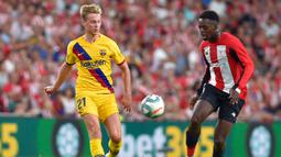 Gelandang Barcelona, Frenkie de Jong, berebut bola dengan penyerang Athletic Bilbao, Inaki Williams, pada laga pekan pertama La Liga 2019-20 di stadion San Mames, Bilbao, Jumat (16/8). Barcelona kalah 0-1 dari Athletic Bilbao. (AFP/Ander Gillena)