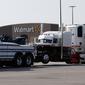 Sebuah truk ditarik dari lapangan parkir supermarket di Texas, Minggu (23/7).  Delapan orang ditemukan meninggal dunia di dalam truk itu, sedangkan satu korban lainnya tewas dalam perawatan di rumah sakit. (AP Photo/Eric Gay)