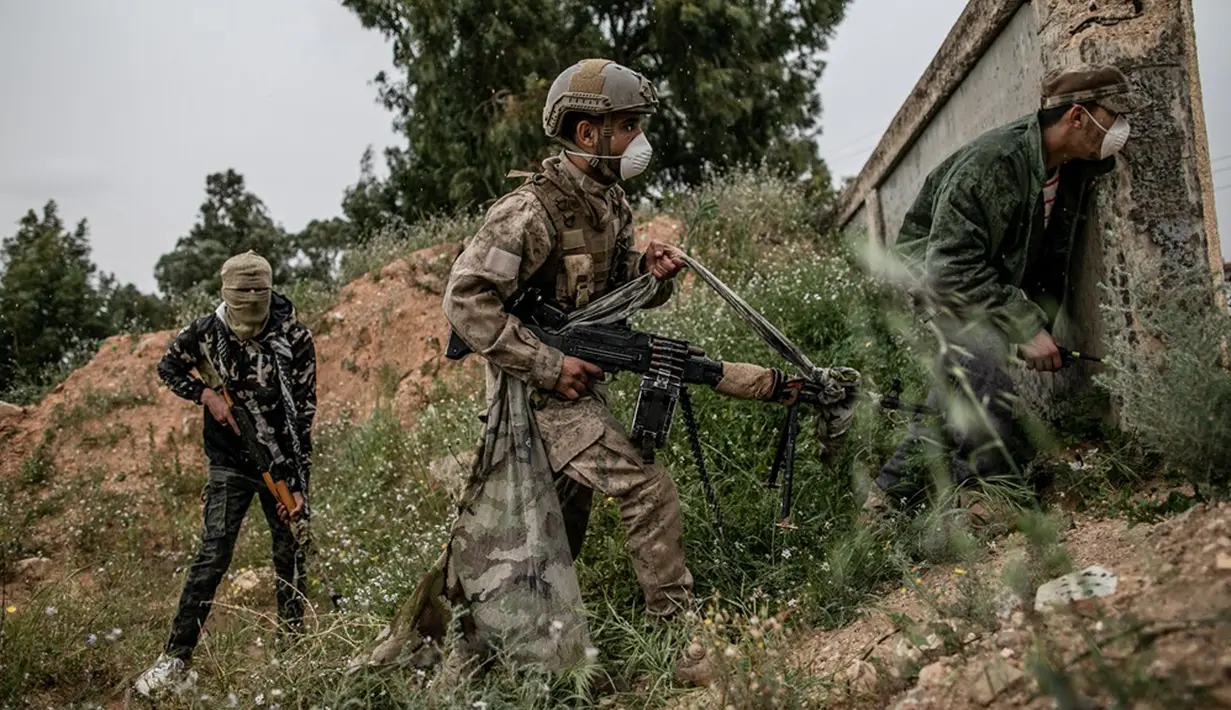 Pasukan GNA berlindung dalam pertempuran dengan Tentara Nasional Libya (LNA) di Tripoli, Libya (25/3/2020). Menteri Kesehatan pemerintah Libya yang didukung PBB Ehmid Bin Omar pada Selasa (24/3) mengumumkan infeksi COVID-19 pertama di negara tersebut. (Xinhua/Amru Salahuddien)