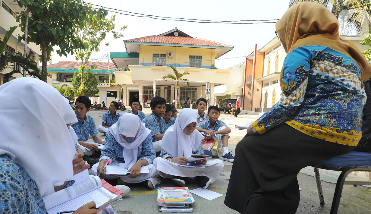 Siswa kelas VIII belajar mata pelajaran Sejarah Kebudayaan di halaman sekolah Mts. Hidayatul Umam di Cinere, Depok, Kamis (7/11/2019). Kementerian PPPA melaksanakan kegiatan hari belajar di luar kelas yang serentak di seluruh Indonesia pada Kamis (7/11). (merdeka.com/Arie Basuki)